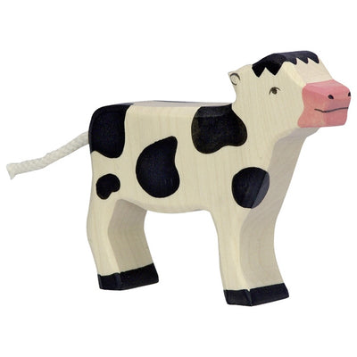 Veau noir et blanc debout Holztiger